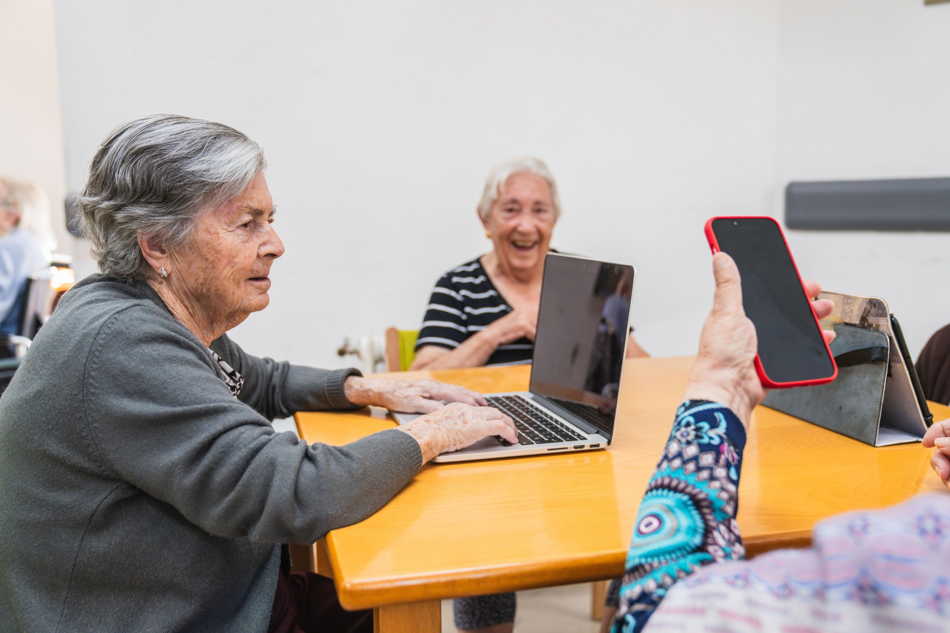 Elderly women engaging with technology in nursing home