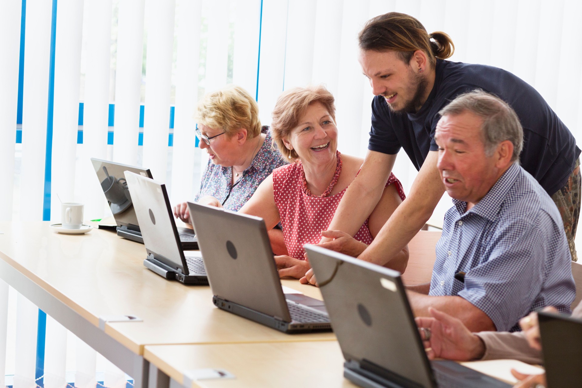 young teacher and senior adults learning in computer lab